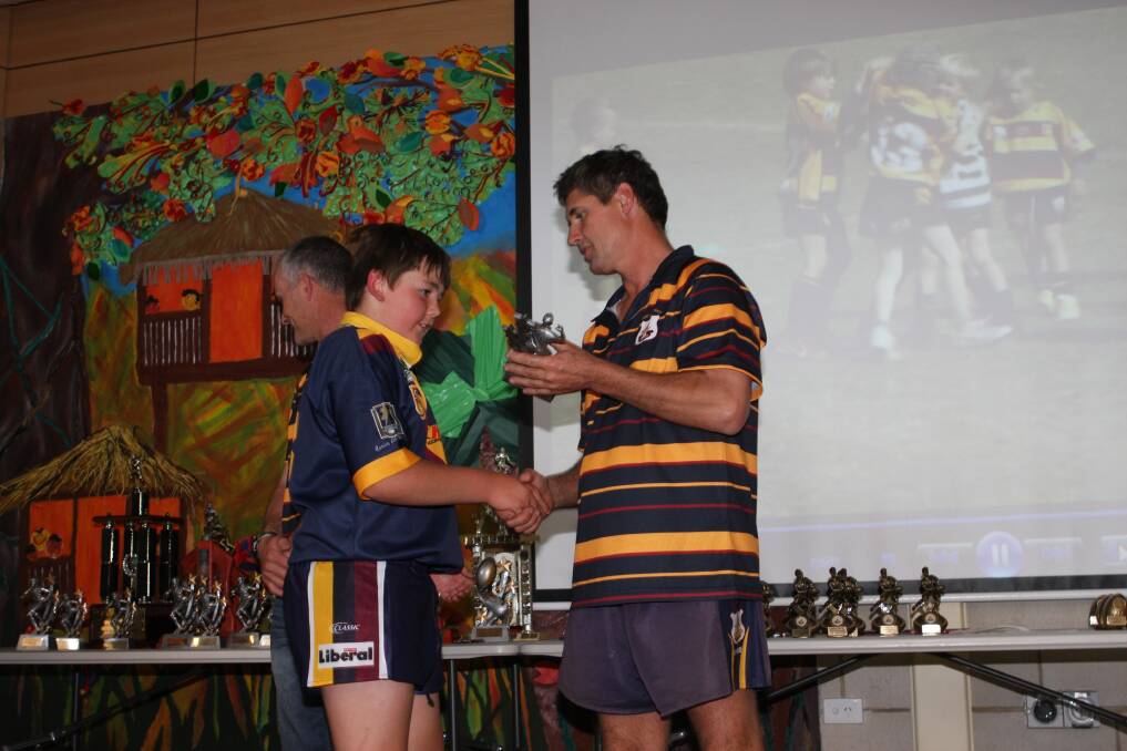 St John's Blue coach Tim Nelson presenting Thomas Stimpson with his most improved player award.