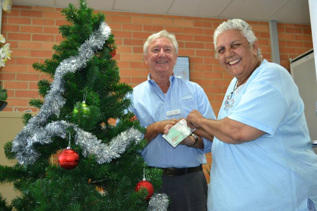 PERFECT TIMING: Compass Housing community development officer Paul Cheshire handing the first prize $200 Coles Myer gift voucher to resident Robin Payne. 	 
 
          Photo: ABANOB SAAD