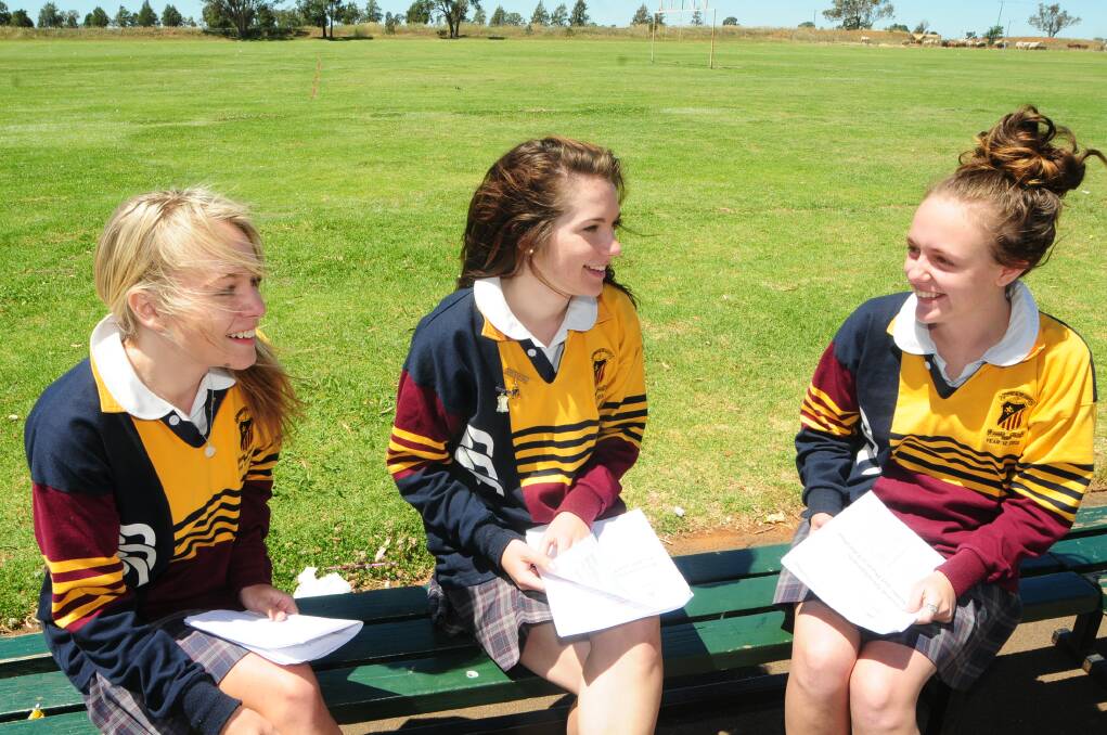 SJC Year 12 students Emily Hayes, Amy Armstrong and Belle Haycock discuss the exam paperPHOTO: CHERYL BURKE