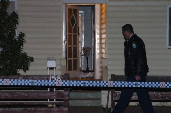 Police investigating the scene in Fitroy Street where George Thomas Howlett was gunned down after answering a knock at his front door on June 8 2004.