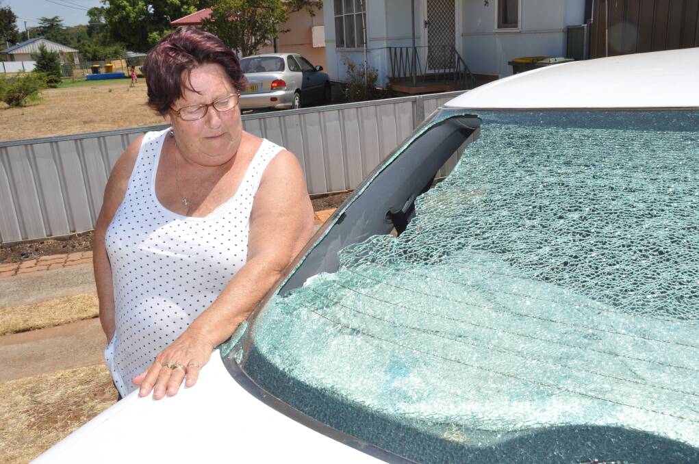 Carole Kilsby alongside her car minutes after children had used a rock to smash the back window.			      Photo: LISA MINNER