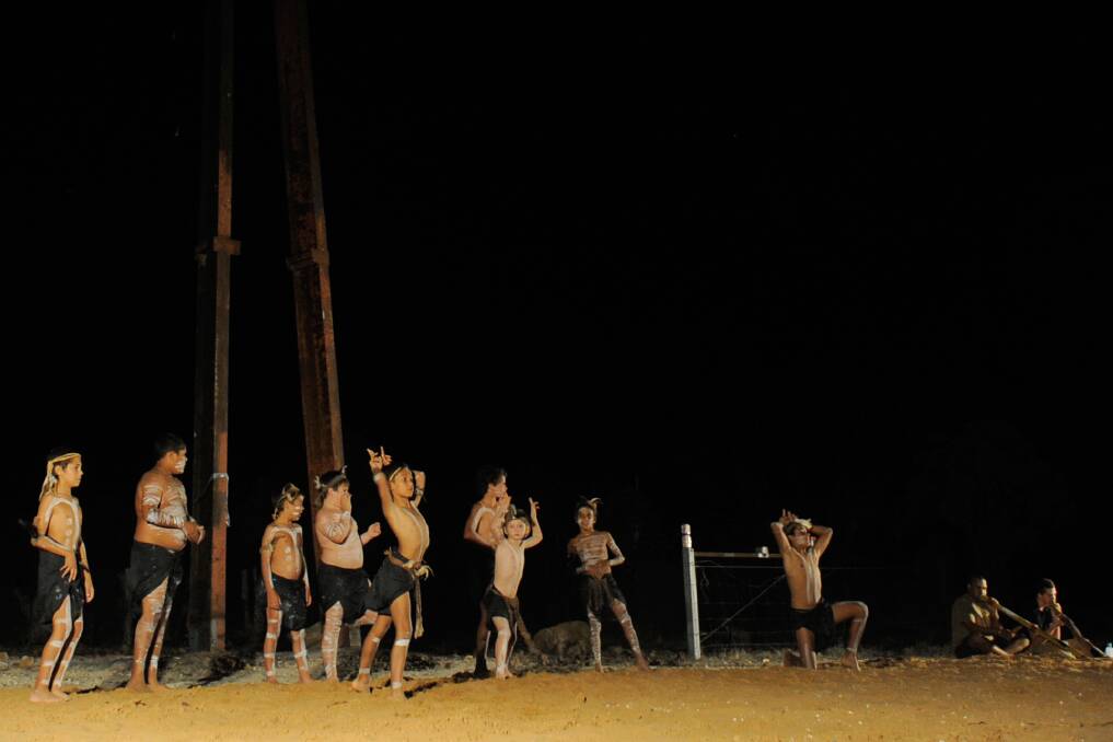 A local Lightning Ridge Indigenous dance group performs underneath the statue