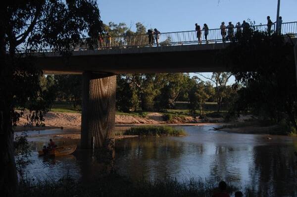 Onlookers line the bridge as police and volunteer rescue workers scour the Castlereagh River for a missing four-year-old girl in Gilgandra last night. Photos: AMY GRIFFITHS