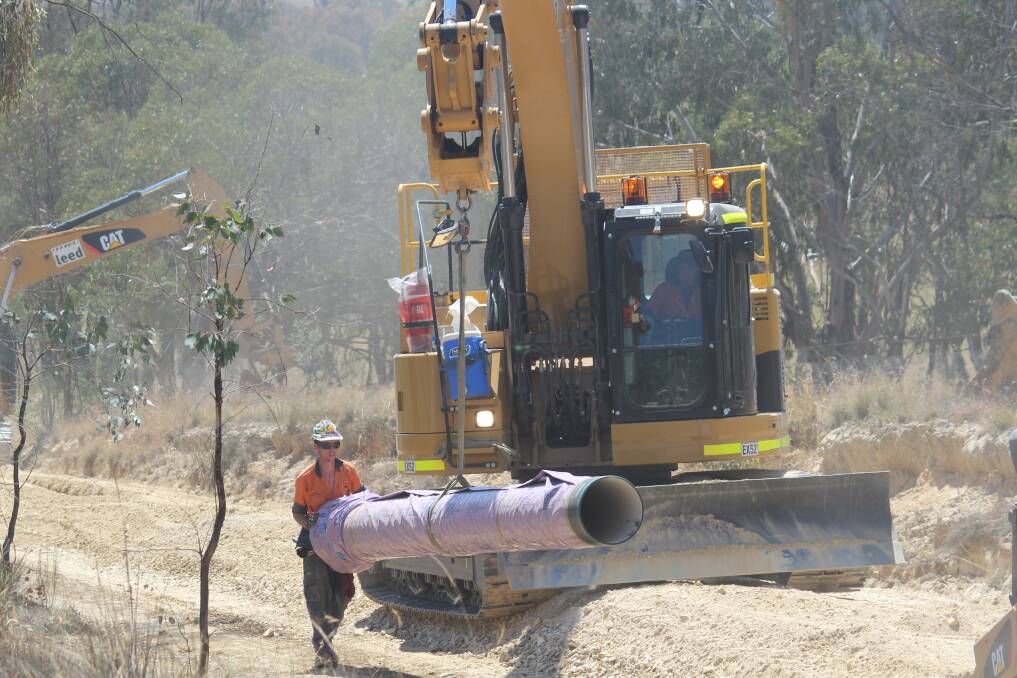 Workers lay pipe along Long Point Road. Photo MELISE COLEMAN