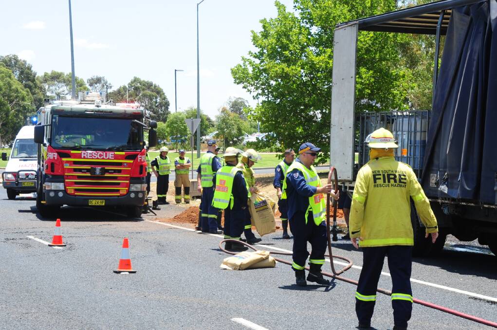 Dubbo Fire and Rescue and HAZMAT crews work to clean up a molsses spill on the Mitchell Highway yesterday, near Orana Mall. Photo: BELINDA SOOLE