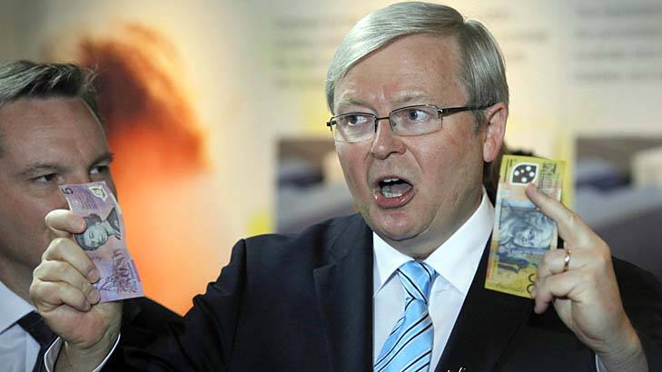 Take note: Kevin Rudd uses cash to make a point at Westmead Hospital on Sunday as Treasurer Chris Bowen watches. Photo: Andrew Meares