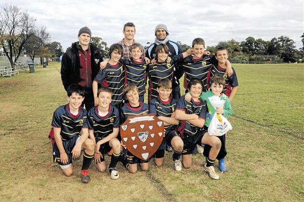 St Mary’s Catholic School players after their win in the David Peachey Shield yesterday at Apex Oval. They are pictured with Peachey (right), Russell Richardson and Manly Sea Eagle player Ben Farrar (left). The St Mary’s team was made up of Kobi Wilson, Ben Carolan, Ethan Yeo, Daniel Duffy, Patrick Saul; (front) Charlie Spora, Sam Thompson, Jono Davis (c), Harrison Carlow, Paddy Haycock with young