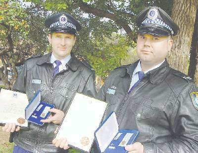 COURAGEOUS: Constable Rick Wilson and Senior Constable Shannon Fletcher were recognised for saving a man from the burning wreckage of his car (right) that exploded just seconds after they pulled him free. Photos: IVAN McDONNELL