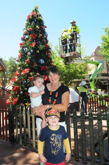Maree O'Connor and grandchildren Lachlan, 3, and Molly, 2, welcome the city's Christmas tree as workers add the finishing touches to the decorations.	 
	 Photo: AMY McINTYRE