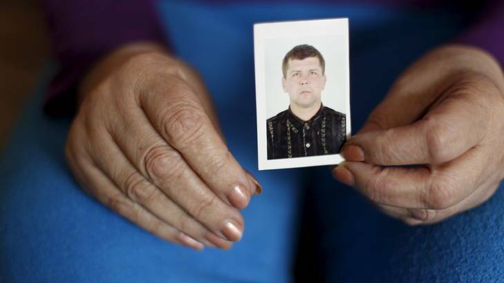 “Two ribs, two Achilles heels, two elbows, two eardrums, two teeth, and so on'' ... a relative holds a picture of Oleksandr Frolov, some of whose body parts were found during a raid by Ukrainian authorities.