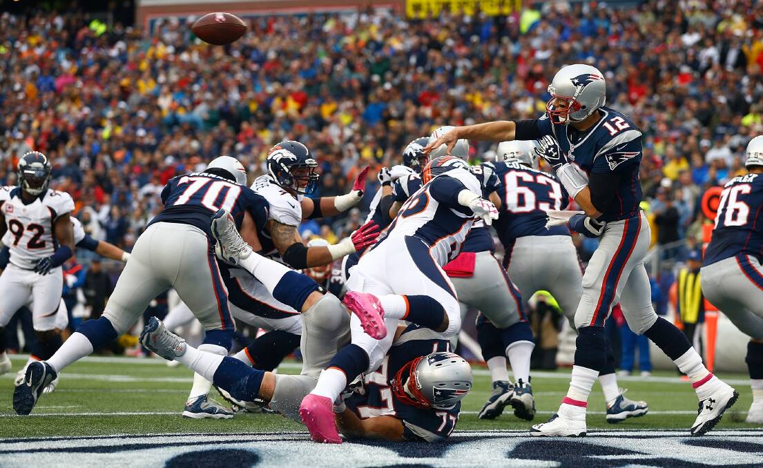 Despite the Denver Broncos defence rushing at him, New England quarterback Tom Brady gets a pass away. 	Photos: GETTY IMAGES