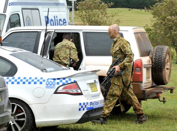 A specialist police group dressed in camouflage prepare to leave the Nowendoc Hall in the manhunt for Malcolm Naden yesterday. Photo: Barry Smith.
