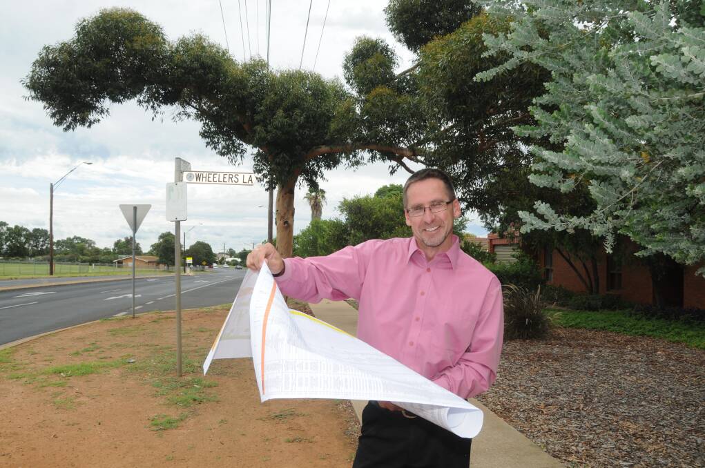 Dubbo City Council's Ian McAlister with the tree selection matrix that will prevent repeats of poor choices, like the species on the corner of Birch Avenue and Wheelers Lane. 
Photo: AMY MCINTYRE