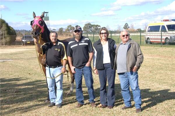 Strapper George Moses with the Tom Mulholland trained Borntaburn and Dubbo based owners Brent and Celina Vannus and Barry Clarke after the gelding took out the Invisible Maiden Handicap (1600m) at Dubbo yesterday.