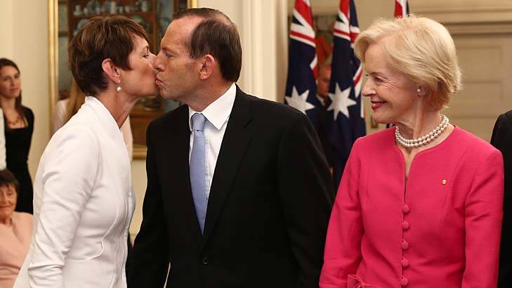 Tony Abbott kisses his wife Margie after he was sworn  in as Australia's 28th Prime Minister by Governor-General Quentin Bryce, right. Photo: Andrew Meares
