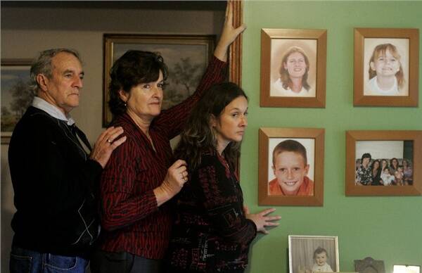 Jim and Helen Bragg with their daughter Sharon Bragg. They lost family members who died in the Pacific Highway collapse in 2007. Pictures on the wall show (top left to right) deceased Roslyn Bragg, Madison Holt, Travis Bragg (bottom left).