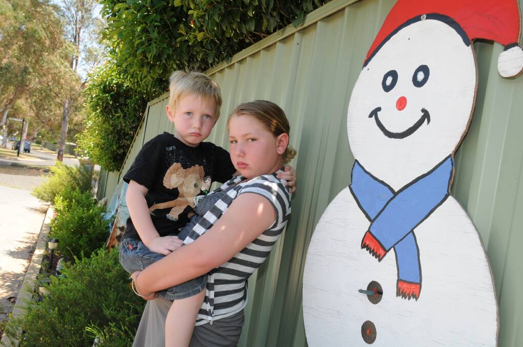 Bradley, 4, and Courtney Russell, 9, are upset about the theft of their family s Santa cut-out which was made by their older brother and sister many years ago. 
	Photo and story: LISA MINNER