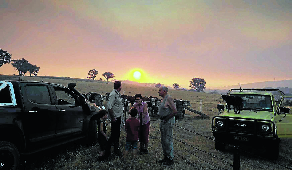 BATHURST: Matt Molloy with his children Oliver, 5, and Mitchell, 7, chat with his parents on the neighbouring property Paul and Deirdre Molloy about the fire at Hells Hole. Photo: ZENIO LAPKA 012014zneville