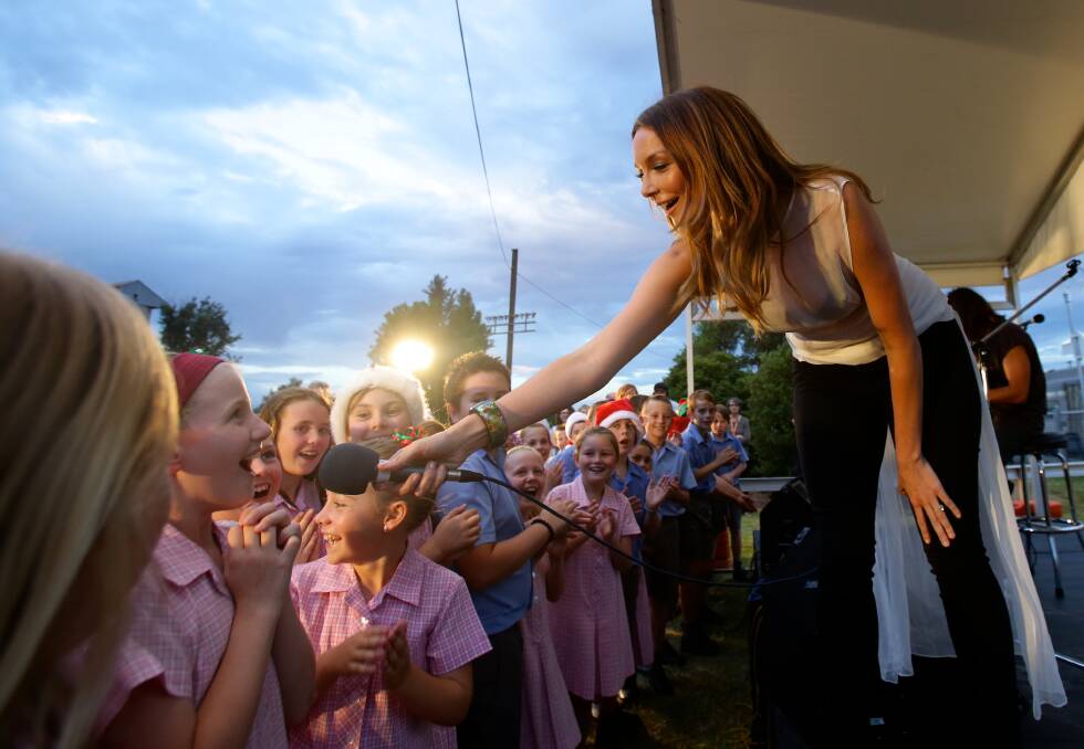 Ricki Lee offers a young girl the mike during her performance in Bathurst. Photo: Dallas Kilponen