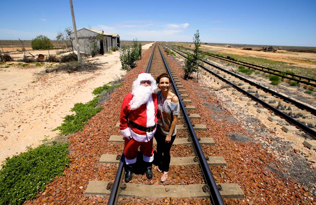 Ricki Lee with Santa Claus on the longest stretch of straight raliway track in the world at Cook on the Nullarbor Plain. Photo: Dallas Kilponen