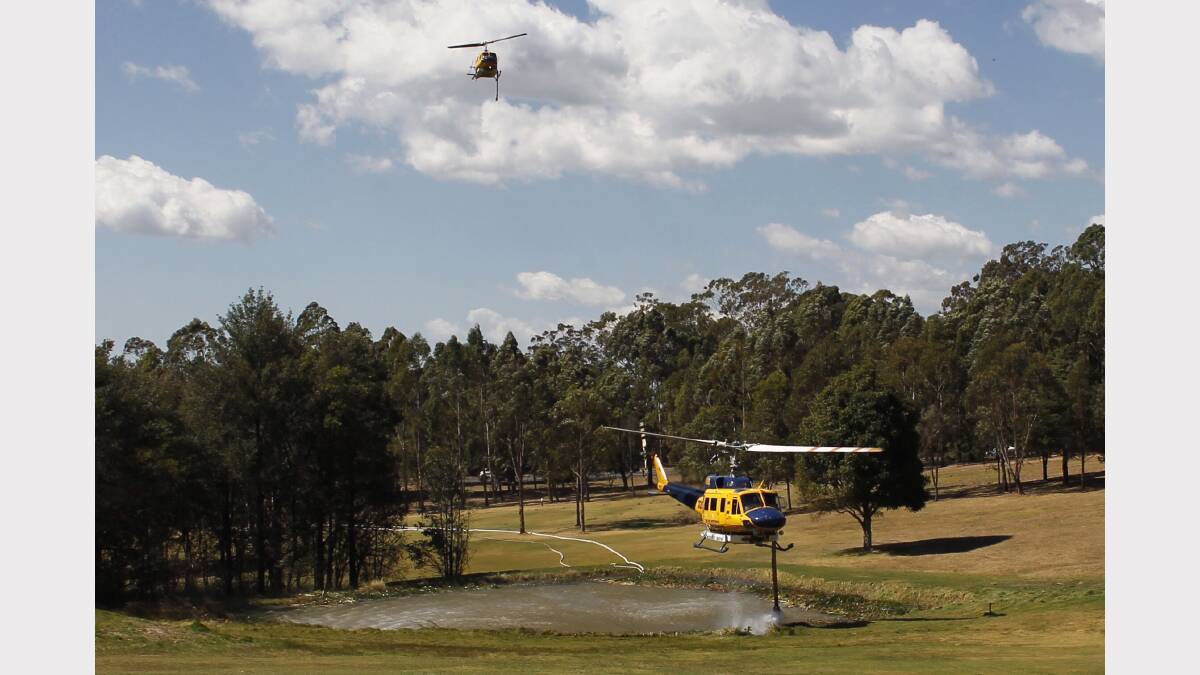   Water bombing helicopters fill up at Springwood Golf Course.  PHOTO: GEOFF JONES .