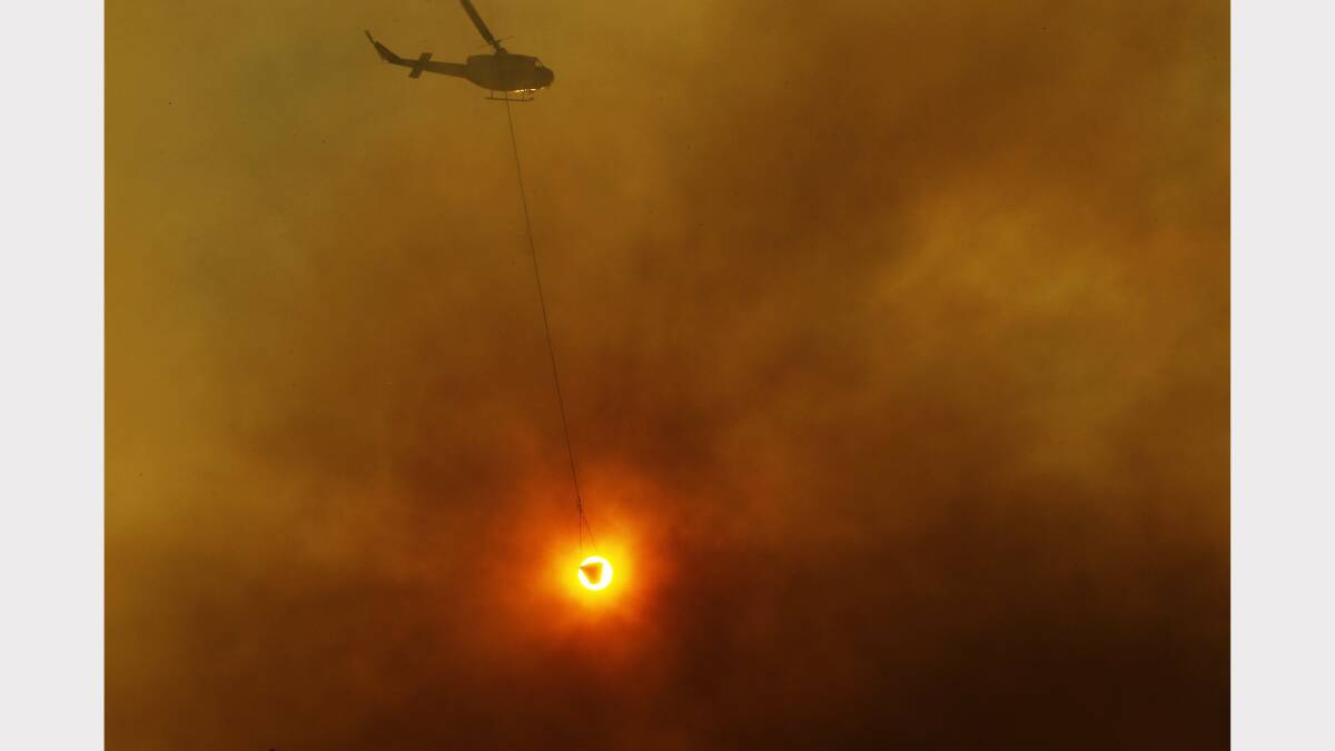 Redhead fire burning in the Awabakal Reserve. Picture shows a water bombing helicopter at work. Picture by Max Mason-Hubers 