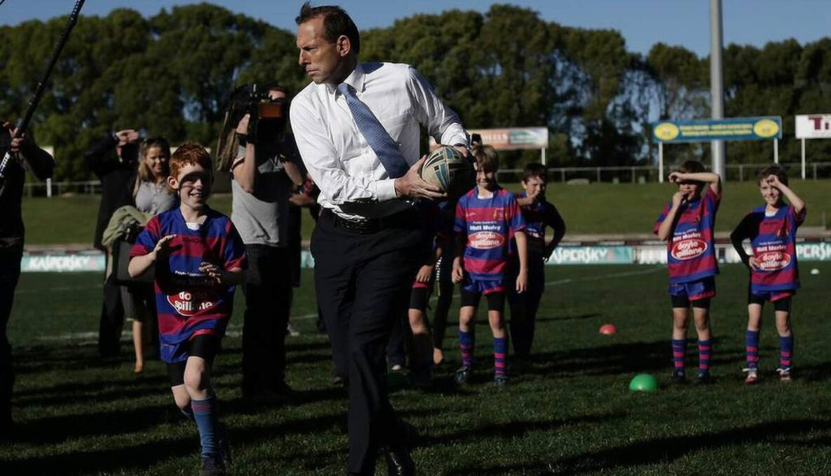 Opposition Leader Tony Abbott has a throw with the Under-9 Manly Christian Brothers players during his visit to Brookvale Oval in NSW. 