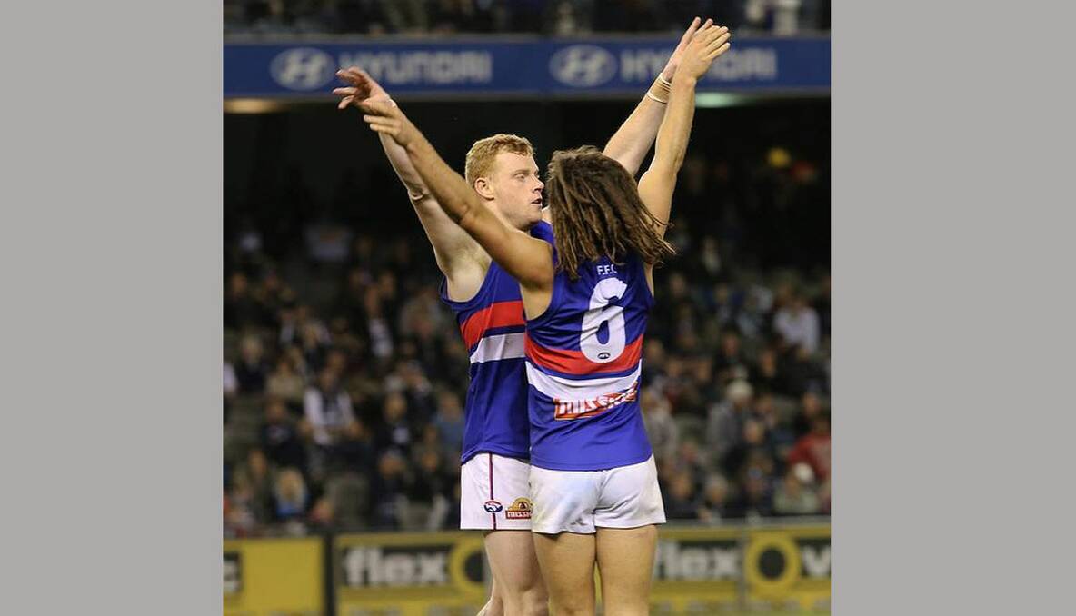Adam Cooney and Luke Dahlhaus (WB) celebrate after Cooney scored a goal to just about seal the game in the last quarter. Photo: Justin McManus 