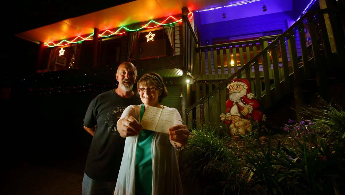SCORE CARD: Glenn and Jo Currington of 47 Kenley Crescent, Macquarie Hills, with their card with a score of B from the Friendly Neighbourhood Christmas Lights Critic. Pictures: Peter Stoop