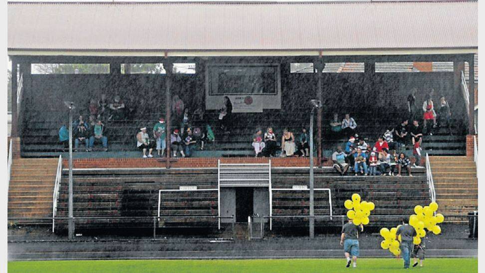 Keen carolers retire to the grandstand to avoid the downpour in 2010. 