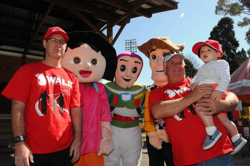 BATHRUST: Scott Forde, his dad Mick and little Harry Forde, 14 months, were joined by a group of cartoon characters at yesterday’s Walk for Red Day. Photos: ZENIO LAPKA 090113zred1