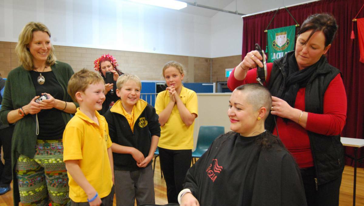 CANOWINDRA: Hairdresser Kylie Lawrence shaves Canowindra Public School teacher Jess Swords' head as Peta Laurie, Cayless Dunn, Shani Nottingham, Dustan Smith and Ellie Giger watch. The fundraising effort will see $2300 donated to cancer care