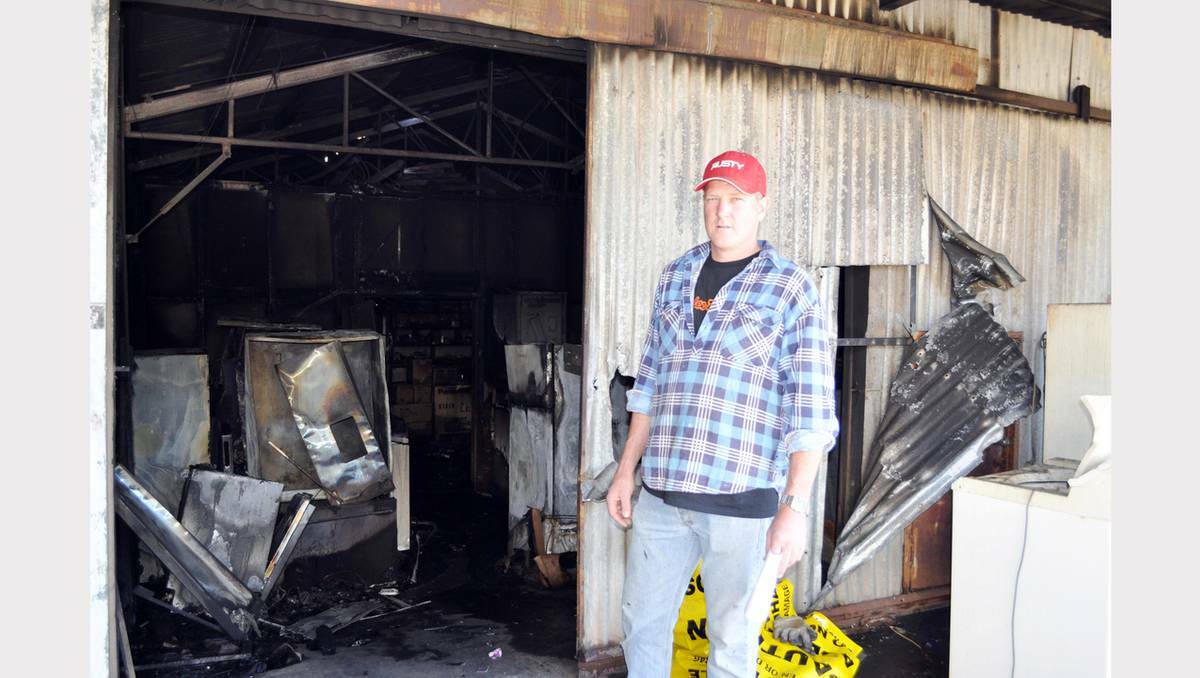 PARKES: Betta Home Living owner, Ian Westcott surveys the damage to the business after the fire early Saturday morning.