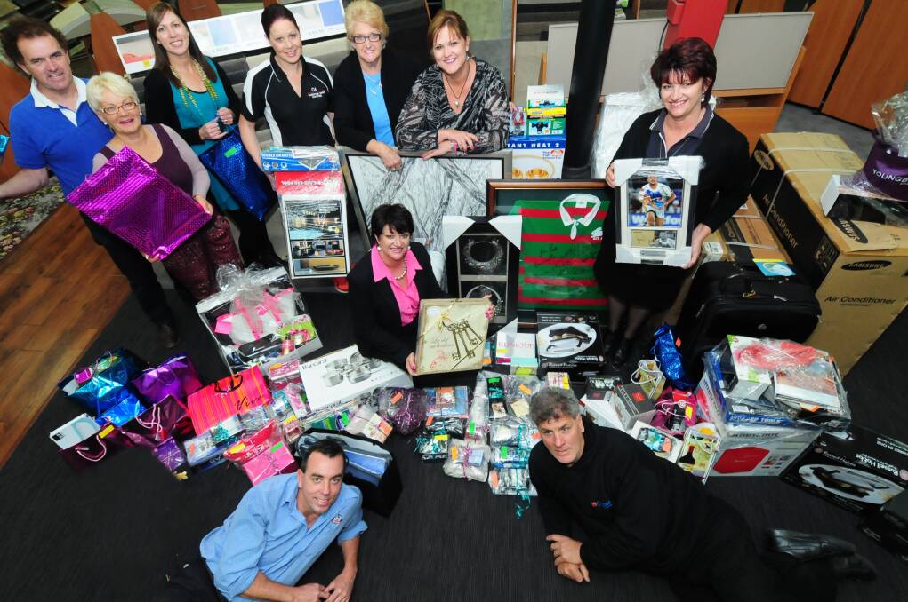 Members of the committee organising the Warwick "Wocka" Rapley Memorial Dinner inspect donations for silent and live auctions, and raffles. They are (back, from left) Mick Picton, Donna O'Brien, Katrina Reynolds, Chrystal Thompson, Barbara Ginn, Donna Falconer, and (front, from left) Tony Quinn, Sharon Allan, Susie Webster and Stephen O'Brien.  Photo: LOUISE DONGES