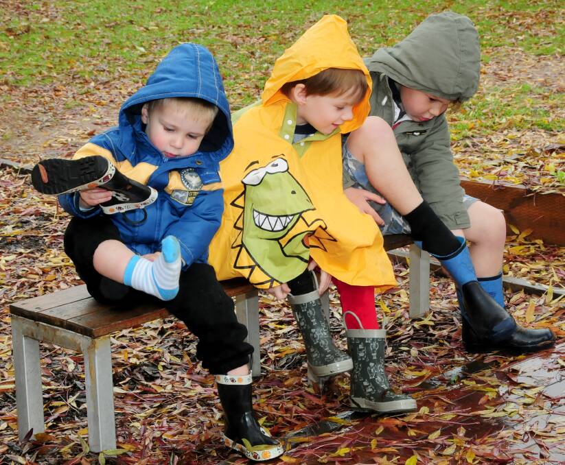 Gearing up for wet weather play at Dubbo's Rainbow Cottage childcare centre yesterday are Austin Reynolds, Angus Mein and Tate Wootton. Photo: LOUISE DONGES