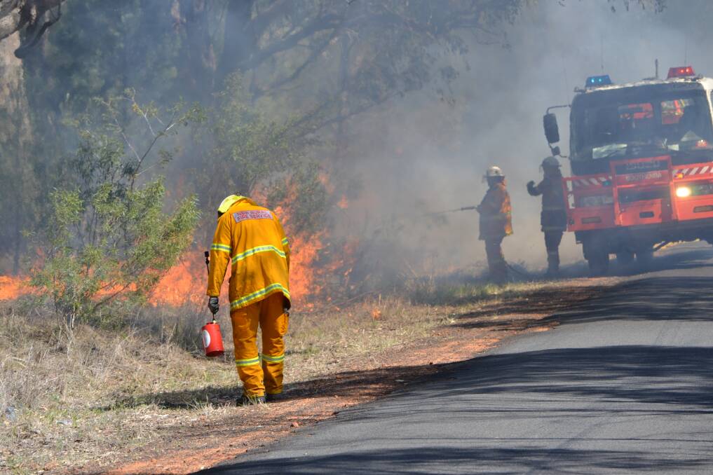 Ryan Bass sets a controlled fire to the easement on the rail line along Minore and Rosedale roads. Photos: SIMON CHAMBERLAIN.