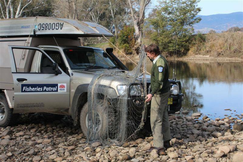 DUBBO: DPI Fisheries officer Peter Heath with one of the seized gill nets. Photo contributed