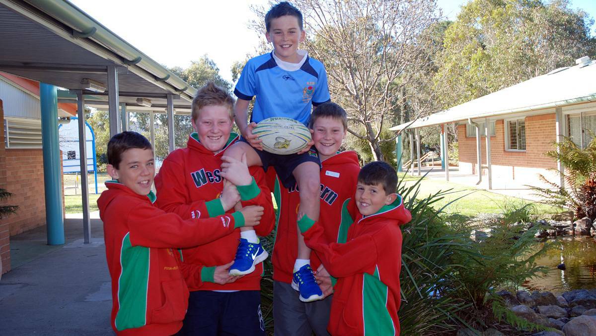LITHGOW: STAR rugby league representative Pacey Stockton returned to the Wallerawang Primary School to a hero’s welcome. Pictured:  Pacey is hoisted above by his mates (from left) Dylan Miles, Thomas Fraser, Hayden Wittingslow and Sam Lane. lm081513pacey