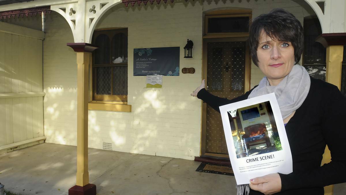 BATHURST: A Settlers Cottage owner Gerarda Mader with a photo of the antique timber chair that was stolen from the front verandah of the Keppel Street cottage over the weekend. Photo: CHRIS SEABROOK 052713chair1a