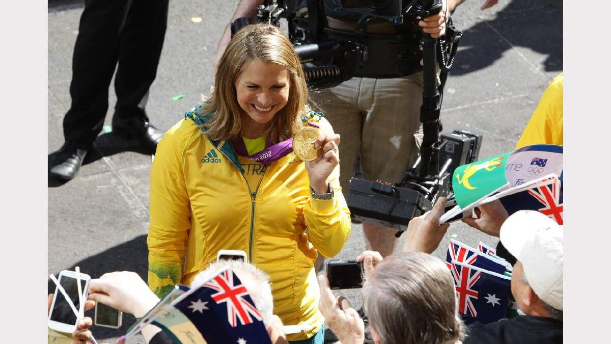 Swimmer Libby Trickett shows off her medal to the crowd at the official welcome home parade today.