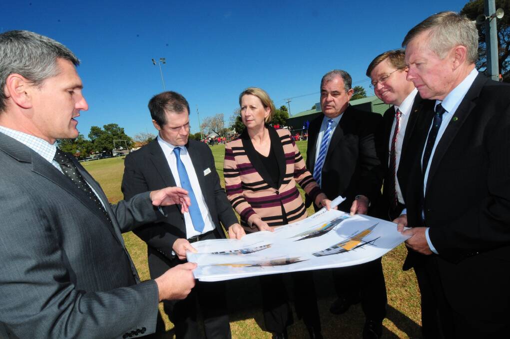 Murray Wood from Dubbo City Council, Dubbo mayor Mathew Dickerson, Minister for Regional Development Sharon Bird, Regional Development Australia - Orana chairman John Walkom, state Member for Dubbo Troy Grant and federal Member for Parkes Mark Coulton inspect the plans for the 500-seat grandstand and all-weather track. 	Photo: LOUISE DONGES