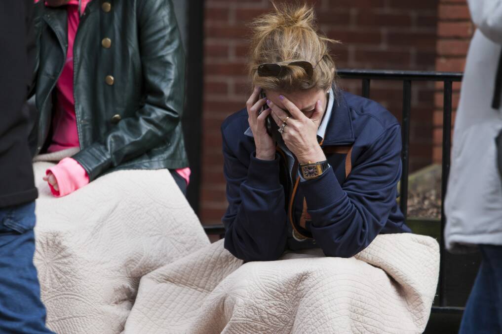 A woman talks on the phone after two explosions interrupted the running of the Boston Marathon in Boston. Photo: Reuters
