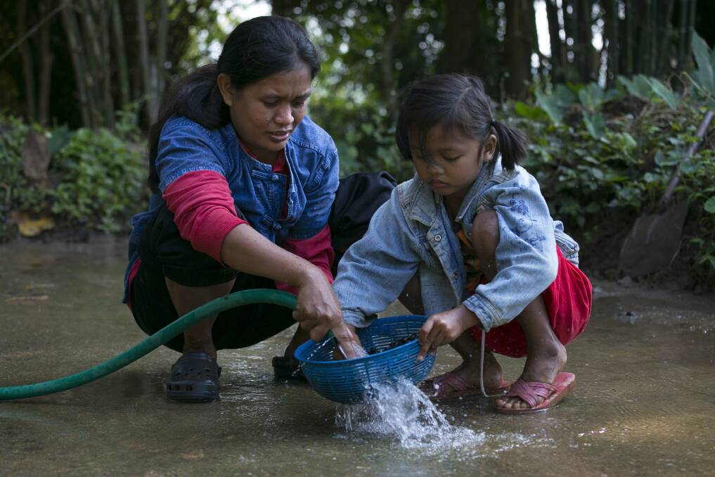 Niang, a mahout's wife and her daughter Ari, 6, wash the coffee beans after picking them from the dung at an elephant camp at the Anantara Golden Triangle resort in Golden Triangle, northern Thailand. Photo by Paula Bronstein/Getty Images