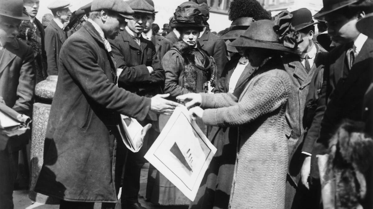 A woman buys a souvenir print of the White Star liner Titanic shortly after the disaster which claimed over 1,500 lives, 1912. Photo by Topical Press Agency/Getty Images