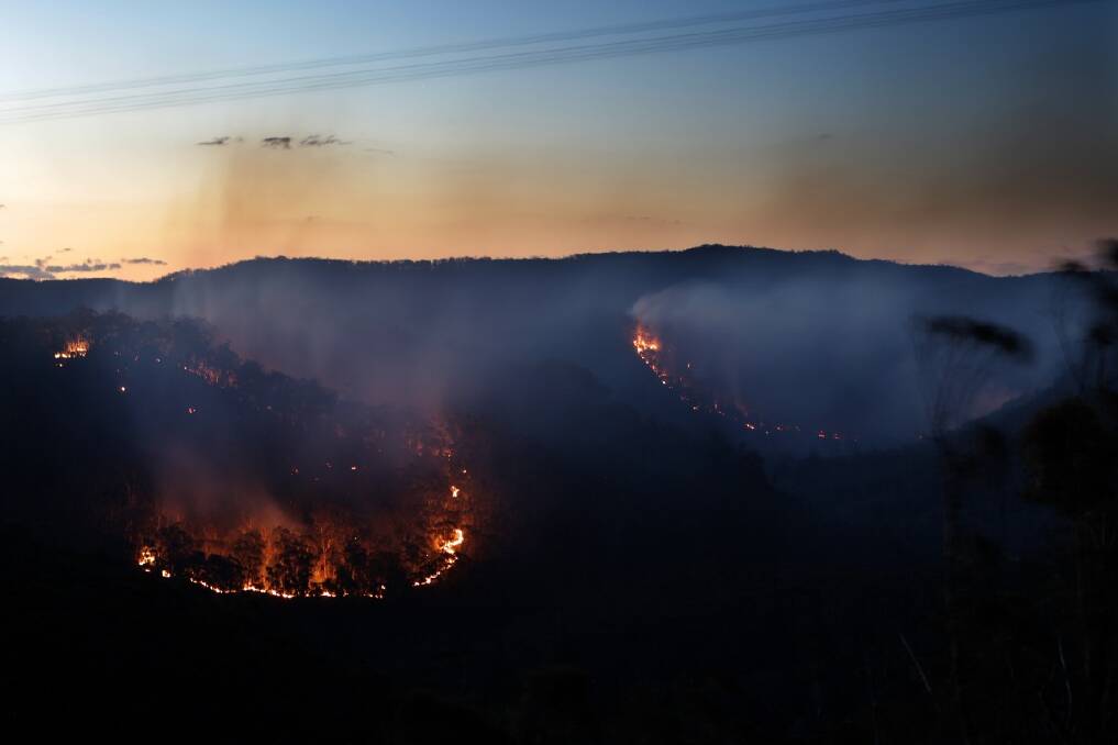 Two rings of fire burn near Hartley Vale in bushland off the Darling Causeway at dusk in the Blue Mountains. Photo: Dallas Kilponen