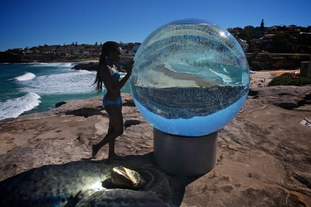 Awa Diagne looking at Lucy Humphrey's sculpture at the Sculptures by the Sea 2013 exhibition. Photo: Danielle Smith 