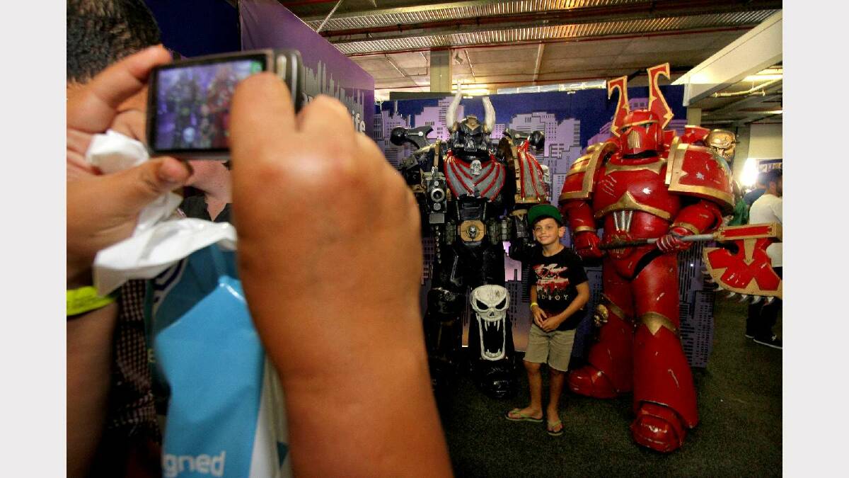 Stanley Huen, 8, has his photo taken with Chaos Space Marines at the Supanova Pop Culture Expo in Brisbane. Picture: Michelle Smith