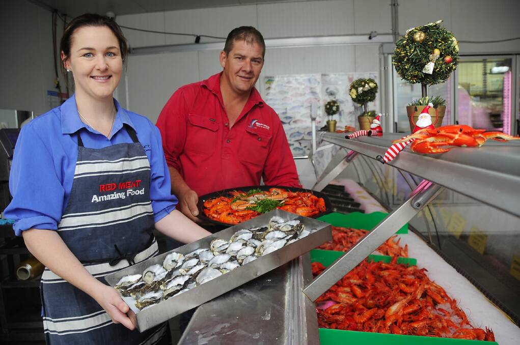 DMC Meat and Seafood’s Hannah Horley helps proprietor Mark Knaggs load up the seafood trays. 			           Photo: BELINDA SOOLE