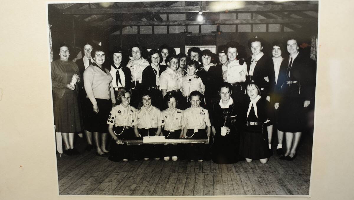 Girl Guides and Leaders posed for a photograph following their lucky escape in the rail crash at Geurie in 1963. The girls pictured in the front row are holding a piece of timber from their damaged rail carriage. 	    Photo: Belinda Soole