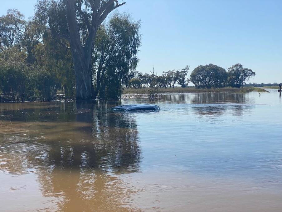 A car which washed off the road in the outskirts of Warren after the driver attempted to drive on a flooded road. Picture via NSW SES